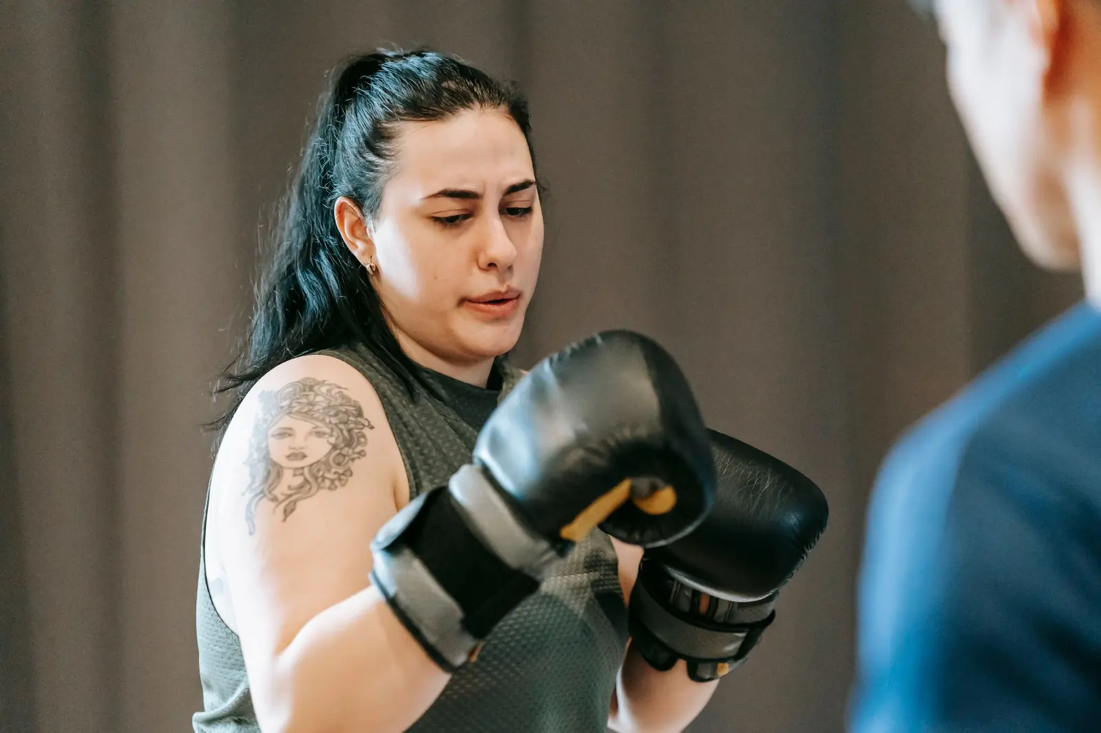 Focused woman in boxing gloves during a training session
