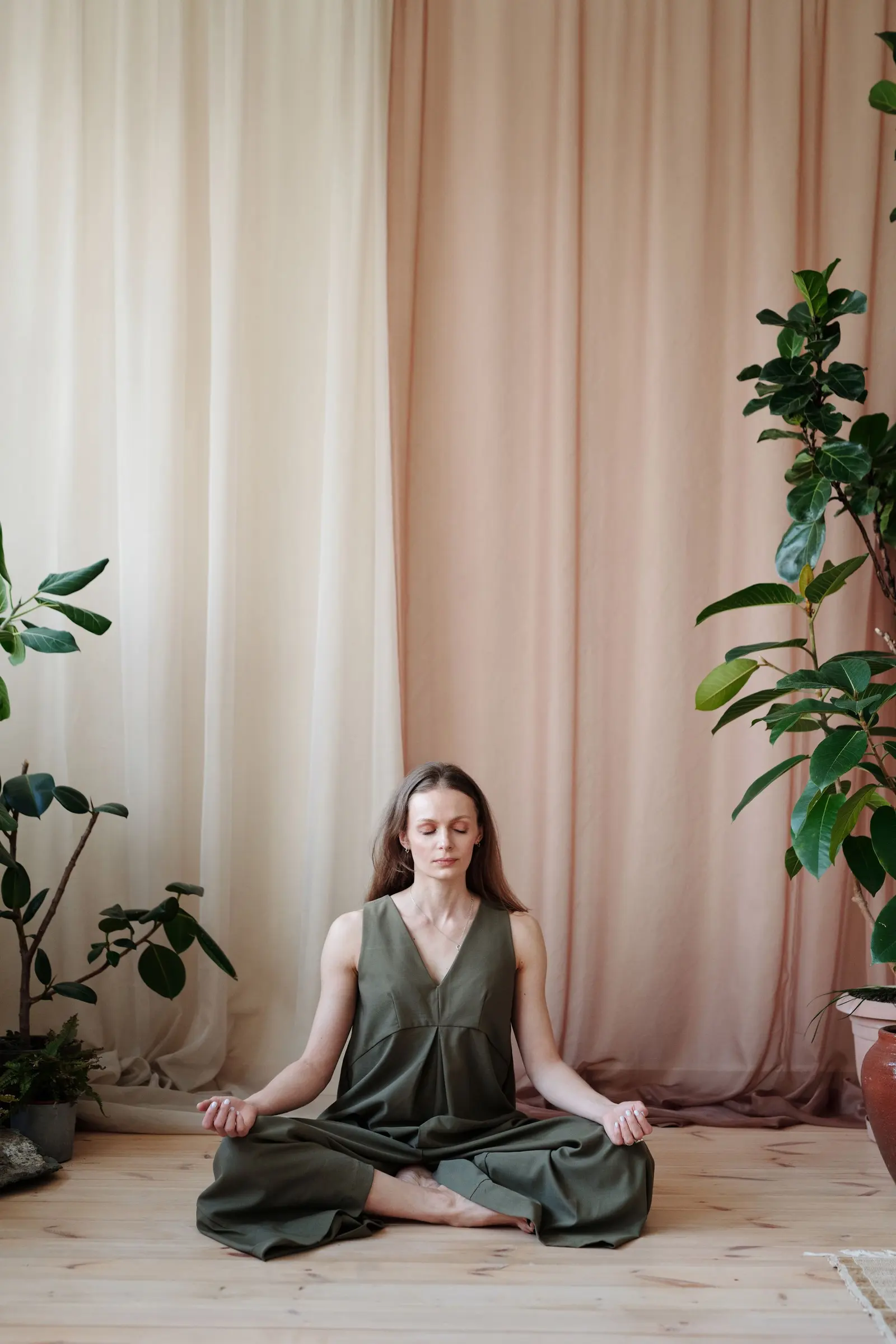 Woman meditating in a calm, light studio with plants